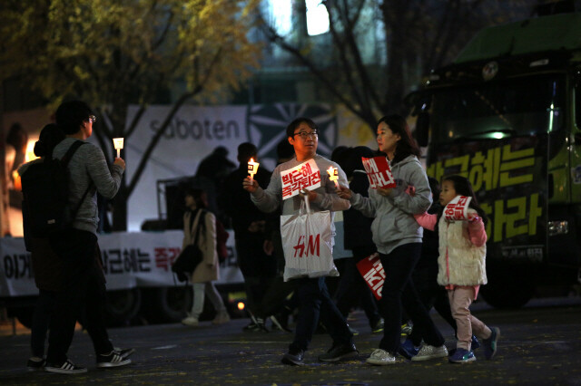 11월19일 서울 광화문광장 촛불집회에서 나란히 걷고 있는 가족. 류우종 기자