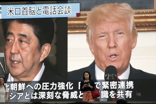 A Tokyo citizen passes in front of a television monitor airing a report on US President Donald Trump’s phone conversation with Japanese Prime Minister Shinzo Abe on Sept. 4.  (AP/Yonhap News)