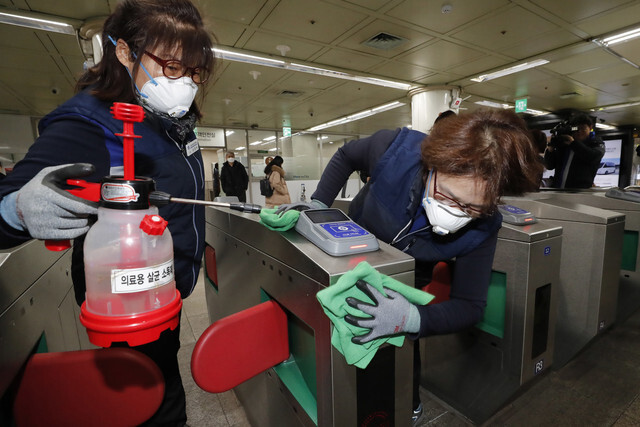 Seoul Metro workers sanitize turnstiles at Gwanghwamun Station on Jan. 28 in an effort to prevent the spread of a new coronavirus that's infected thousands in China. (Lee Jeong-a, staff photographer)