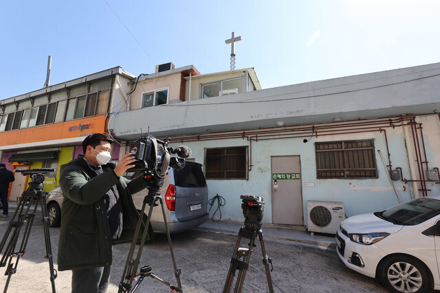 Reporters crowd the entrance of the River of Grace Community Church in Seongnam, Gyeonggi Province, where 46 people have tested positive for the novel coronavirus, on Mar. 16. (Lee Jeong-a, staff photographer)