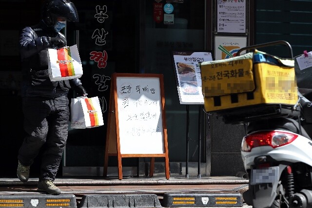 배달대행업체 노동자가 배달할 음식을 받아들고 대구시 한 식당을 나서고 있다. 연합뉴스