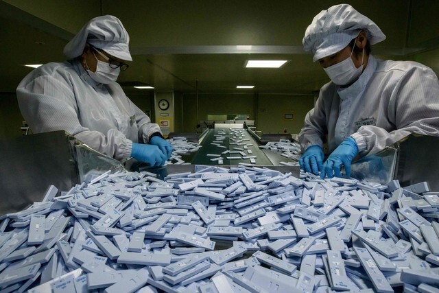 Employees at SD Biosensor in Cheongju, North Chungcheong Province, inspect the quality of diagnostic kits for COVID-19 on Mar. 27. (Yonhap News)
