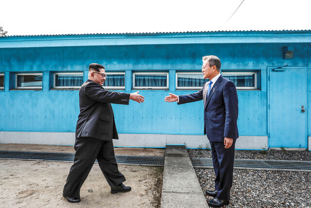 A scene from the documentary “Korea, A Hundred Years of War” showing South Korean President Moon Jae-in and North Korean leader Kim Jong-un approaching each other across the Military Demarcation Line to shake hands on Apr. 27, 2018. (provided by the Korean Association of Arthouse Films)