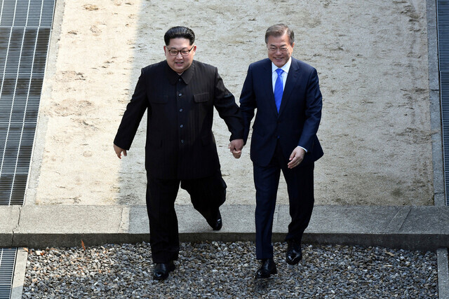 South Korean President Moon Jae-in and North Korean leader Kim Jong-un cross the Military Demarcation Line together at Panmunjom on Apr. 27, 2018. (Yonhap News)