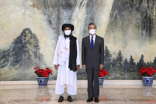 Taliban co-founder Mullah Abdul Ghani Baradar (left) and Chinese Foreign Minister Wang Yi pose for a photo after their talk in Tianjin, China, on July 28. (AFP/Yonhap News)