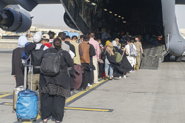 Evacuees board a US military aircraft in Kabul, Afghanistan. (UPI/Yonhap News)