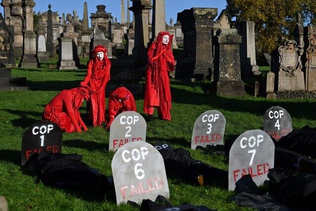 Climate activists disappointed with the COP26 climate agreement hold a protest at a cemetery in Glasgow, Scotland, after the summit came to a close on Saturday. (AFP/Yonhap News)