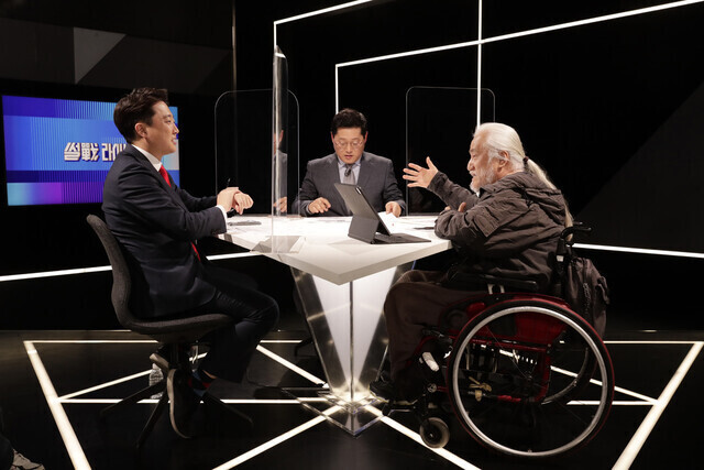 People Power Party leader Lee Jun-seok takes part in a televised one-on-one debate with Park Kyeong-seok, co-representative of the group Solidarity against Disability Discrimination, on April 13. (Kim Myoung-jin/The Hankyoreh)
