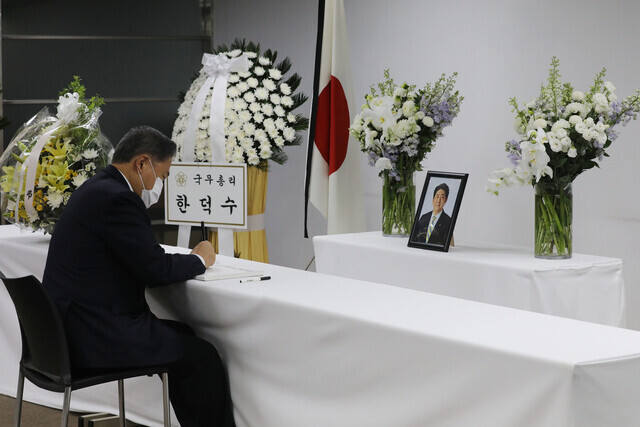 Minister of Foreign Affairs Park Jin writes his name in the visitors’ log of a memorial at the Japanese Embassy in Seoul for Shinzo Abe, the former prime minister of Japan who was killed on Friday. (Yonhap News)