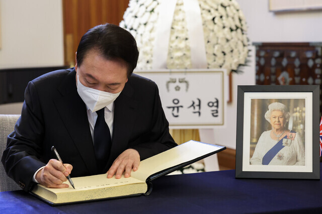 President Yoon Suk-yeol signs the guestbook at the British Embassy in Seoul on Sept. 9 after visiting a memorial altar for the late Queen Elizabeth II set up there. (courtesy presidential office)
