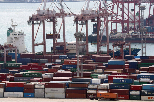 : Freight containers are loaded onto a boat at a port in Busan in this undated photo. (Yonhap)