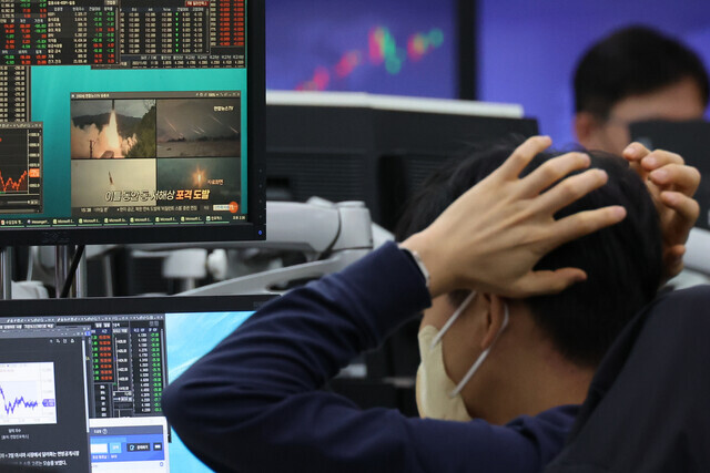 A worker at Hana Bank’s dealing room in downtown Seoul watches news of North Korea’s ballistic missile launch on Nov. 3. (Yonhap)