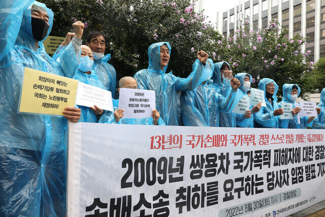 Ssangyong Motor workers targeted by a state lawsuit seeking damages for industrial action hold a press conference on Aug. 30 outside the National Police Agency headquarters in Seoul calling for the suit to be withdrawn. (Yoon Woon-sik/The Hankyoreh)
