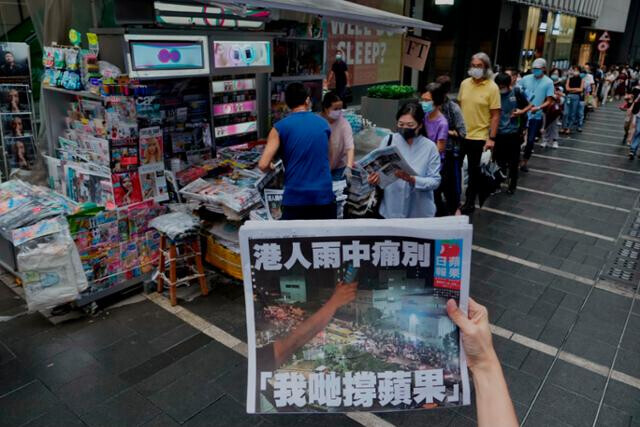A long line of people waits to buy a copy of the Apple Daily, Hong Kong’s most widely known pro-democratic media outlet, before it goes out of print in June 2021. (AFP/Yonhap)