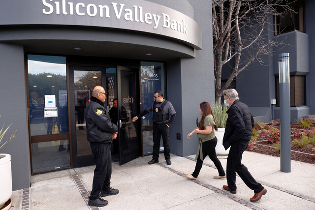 2023년 3월13일 미국 캘리포니아주 샌타클래라에 있는 실리콘밸리은행 앞에서 보안요원이 고객을 안내하고 있다. REUTERS