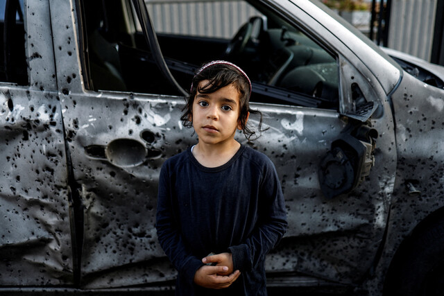 2023년 5월2일 이스라엘 남부 스데로트, 5살 소녀가 가자지구에서 발사한 로켓으로 파손된 차량 곁에 서 있다. REUTER