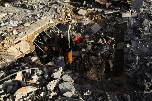 2024년 1월10일 팔레스타인 땅 가자지구 최남단 라파에서 주민들이 이스라엘군의 공습으로 무너진 건물 주변에 모여 있다. REUTERS