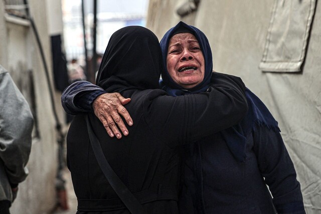 2024년 2월10일 팔레스타인 땅 가자지구 최남단 라파의 알나자르병원에서 전날 밤 이스라엘군 공습으로 숨진 가족의 주검을 확인한 여성들이 끌어안은 채 울고 있다. AFP 연합뉴스