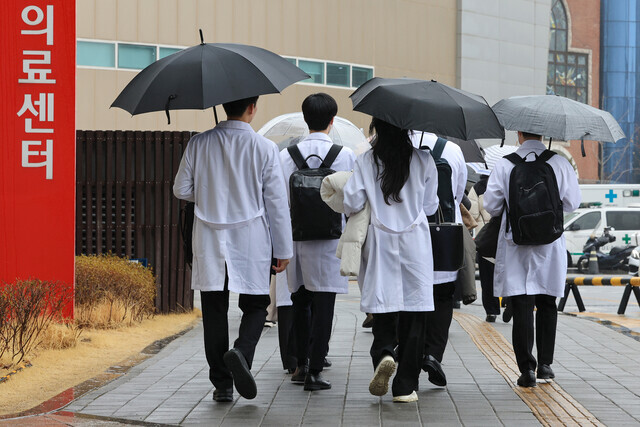Medical staff at a university hospital in Seoul head into the medical center on Feb. 23. (Yonhap)
