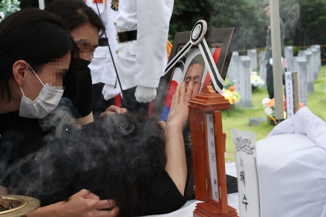 The mother of Lance Cpl. Chae Su-geun weeps over a portrait of her son as he’s laid to rest on July 22, 2023, after died during a search and rescue mission amid torrential rains and flooding on July 19. (Yonhap)