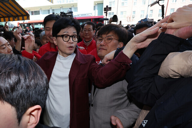 People Power Party interim leader Han Dong-hoon greets supporters as he visits a market in Daegu on March 21, 2024. (pool photo)