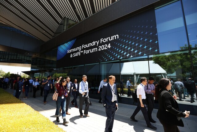 People walk by a sign for the Samsung Foundry Forum & SAFE Forum 2024 in Silicon Valley on June 12, 2024. (courtesy of Samsung Electronics)