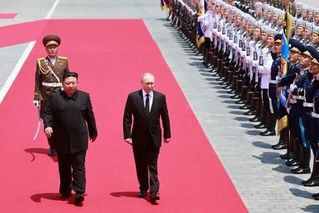 North Korean leader Kim Jong-un and President Vladimir Putin of Russia walk side-by-side at a welcome ceremony for Putin and his delegation held at Kim Il-sung Square in Pyongyang, North Korea, on June 18, 2024. (AFP/Yonhap)
