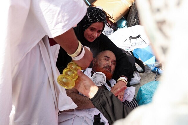 People aid a man who collapsed from heat while on a pilgrimage to Mecca in Saudi Arabia on June 16. At least 31 people were known to have died due to the scorching heat, which hit nearly 50 C (122 F), that day in the vicinity of Mecca. (AFP/Yonhap)