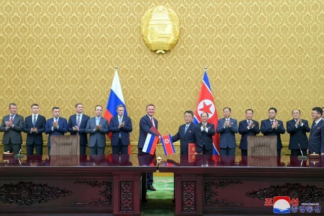 North Korean Minister of Land and Environment Protection Kim Kyong-jun (center right) and Russian Minister of Transport Roman Starovoyt (center left) shake after signing an agreement between their two countries to construct a motorcar bridge over the Tuman River on June 19, 2024. (KCNA/Yonhap)