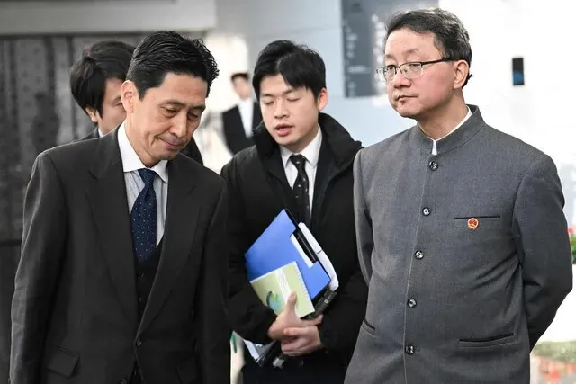 Masaaki Kanai (left), Japan’s top diplomat for Asia and the Pacific, departs from the Chinese Ministry of Foreign Affairs in Beijing on Nov. 18, 2025, after talks amid backlash from China over comments by the Japanese prime minister. (AFP/Yonhap)