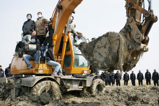 2006년 3월15일 국방부가 경기도 평택 대추리에서 농사를 못 짓게 굴착기를 앞세워 땅을 파내자 주민과 함께 저지하고 있다. 한겨레 장철규 기자