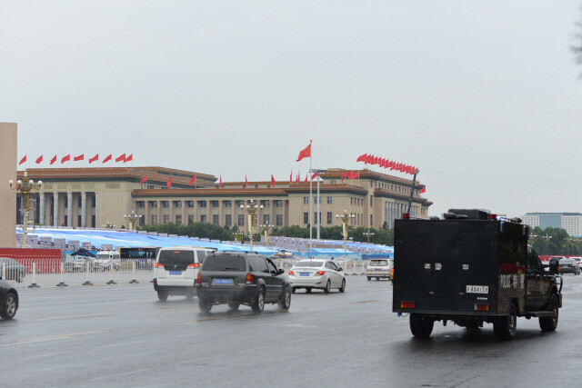Armored special police vans drive in front of Tiananmen Square in Beijing on Sep. 1