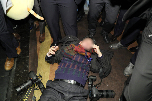A photographer from the Hankook Ilbo lies on the ground after being assaulted by Chinese security personnel while covering an event China National Convention Center in Beijing on Dec. 14. (Blue House Photo Pool)