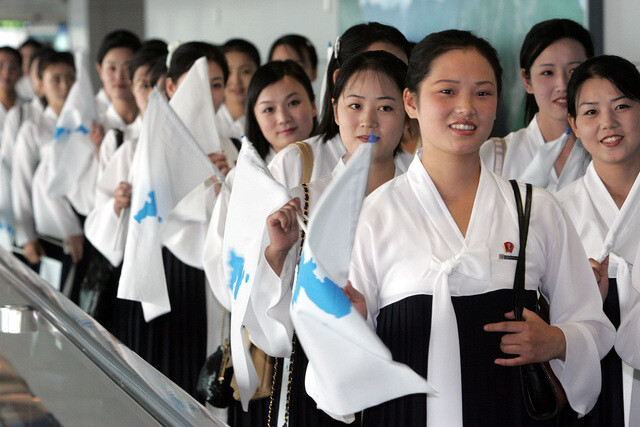 Members of a North Korean cheerleading squad wave the Unification Flag as they arrive at Incheon International Airport on Aug. 31