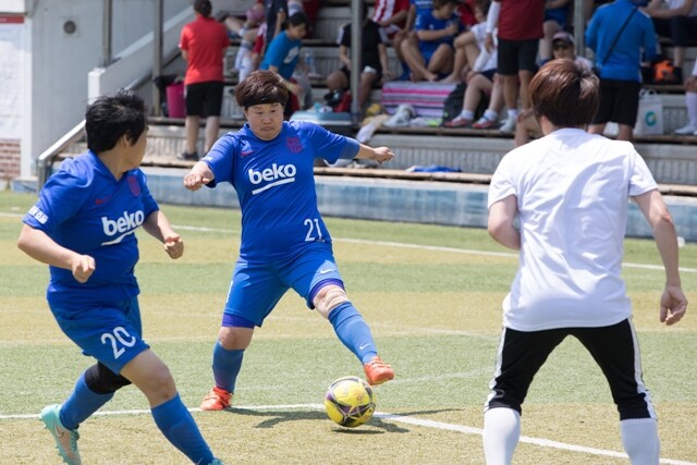 7월6일 서울 송파여성축구장에서 열린 ‘언니들의 축구대회’에서 노원여성축구단 김미경(가운데)씨가 공을 몰고 있다.