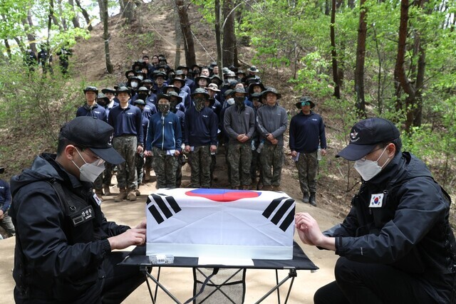 Military personnel and members of the Ministry of National Defense’s exhumation and identification corps prepare exhumed remains to be transported to a temporary place of interment after holding a funeral ceremony on a mountain in Gangwon Province’s Hongcheon County on April 28. (Kim Bong-gyu/The Hankyoreh)