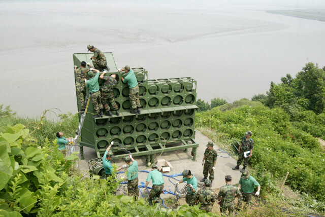 On Aug. 10, 2015, the South Korean military resumed broadcasting on loudspeakers aimed at North Korea for the first time in 11 years. The photo, taken on June 16, 2004, shows South Korean soldiers tearing down the loudspeakers in accordance with the outcome of a summit between top-ranking generals of the two sides. (Yonhap News)