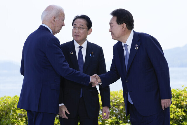 US President Joe Biden greets South Korean President Yoon Suk-yeol and Japanese Prime Minister Fumio Kishida on May 21 ahead of their trilateral summit on the sidelines of the Group of Seven summit in Hiroshima, Japan. (AP/Yonhap)