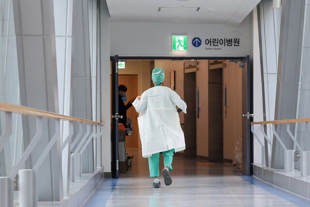 A person in scrubs walks down the hallways at a university hospital in Seoul on March 6, 2024, day 16 of the collective walkout by thousands of the nation’s interns and residents. (Yonhap)