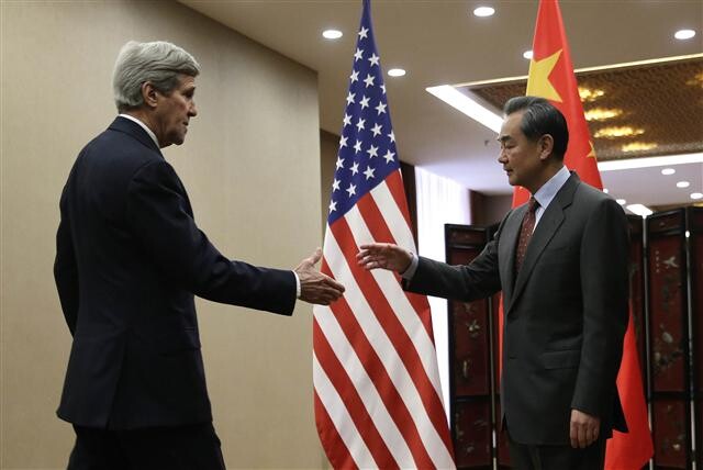 US Secretary of State John Kerry shakes hands with Chinese Foreign Minister Wang Yi at the Foreign Ministry in Beijing