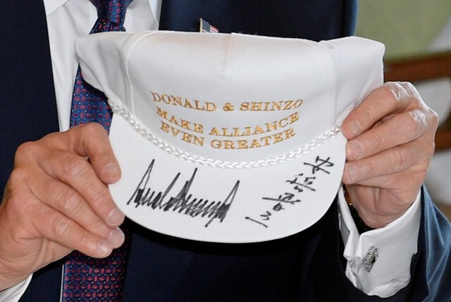 US President Donald Trump shows off a hat that he received from Japanese Prime Minister Shinzo Abe during his visit to the country on Nov.6. The hat is signed by both men. (EPA/Yonhap News)