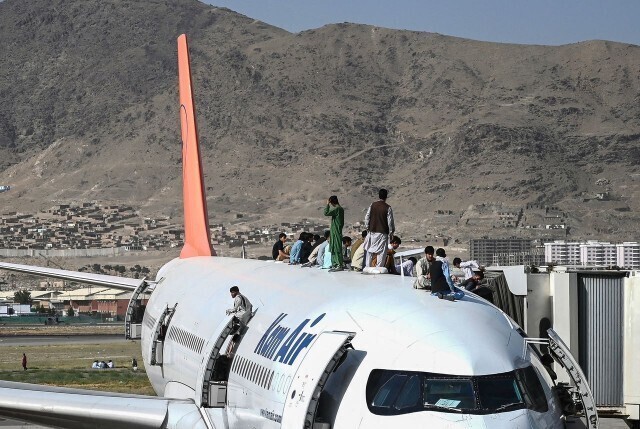 Afghans climb atop a plane as they wait at the airport in Kabul, Afghanistan, on Monday. (AFP/Yonhap News)