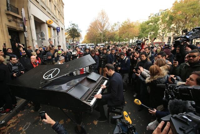 프랑스 파리의 바탕클랑 콘서트홀 앞에서 한 남성이 존 레넌의 <이매진>을 연주하고 있다. 주말에 벌어진 파리 테러는 더 이상 지구촌 어디에 있어도 일상이 안전하지 않다는 공포를 드러냈다. AP 연합뉴스