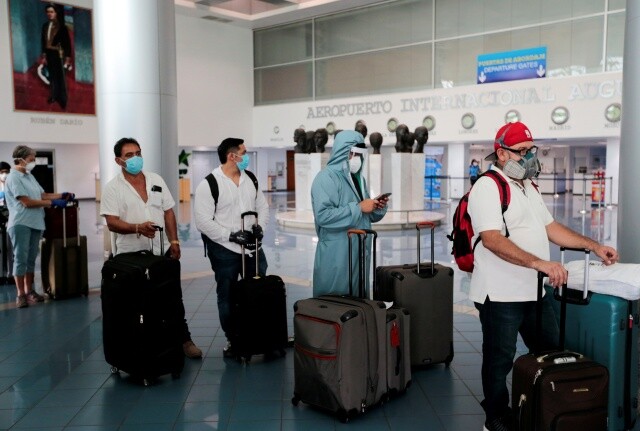 5월20일 니카라과 수도 마나과의 아우구스토산디노 국제공항에서 한 미국인(오른쪽 둘째)이 안면보호구와 마스크, 후드점퍼 등으로 중무장한 채 귀국편 전세기 탑승을 기다리고 있다. 로이터 연합뉴스