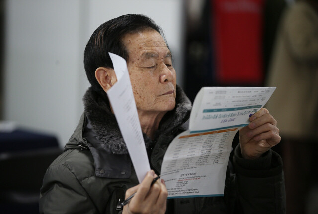 One elderly jobseeker looks over an application form during a job fair at Mapo District Office in Seoul