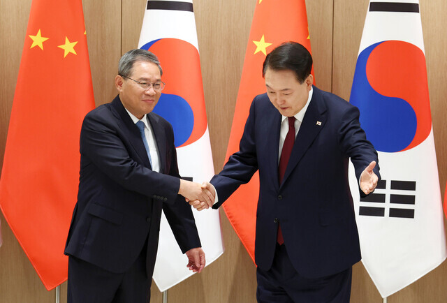 Premier Li Qiang of China shakes hands with South Korean President Yoon Suk-yeol ahead of their summit at the presidential office in Seoul on May 26, 2024. (Yonhap)