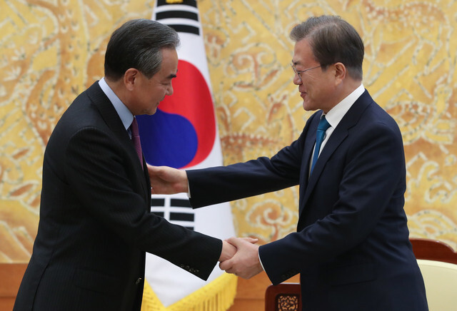 South Korean President Moon Jae-in greets Chinese Foreign Minister and State Councilor Wang Yi at the Blue House on Dec. 5. (Kim Jung-hyo, staff photographer)