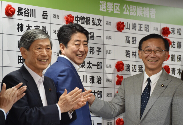 아베 신조 일본 총리(가운데), 고무라 마사히코 자민당 부총재(왼쪽), 다니가키 사다카즈 자민당 간사장이 7월10일 선거 승리를 축하하고 있다. AFP 연합뉴스