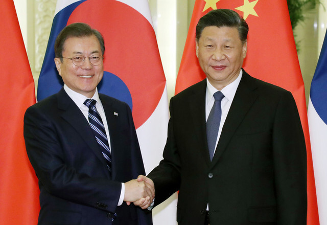 South Korean President Moon Jae-in and Chinese President Xi Jinping shake hands ahead of their summit in Beijing on Dec. 23. (Blue House photo pool)