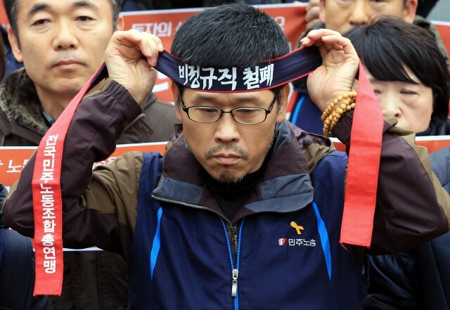 Korean Confederation of Trade Unions president Han Sang-gyun puts on a headband as he leaves the Jogye Order of Buddhism in Seoul’s Jongno district